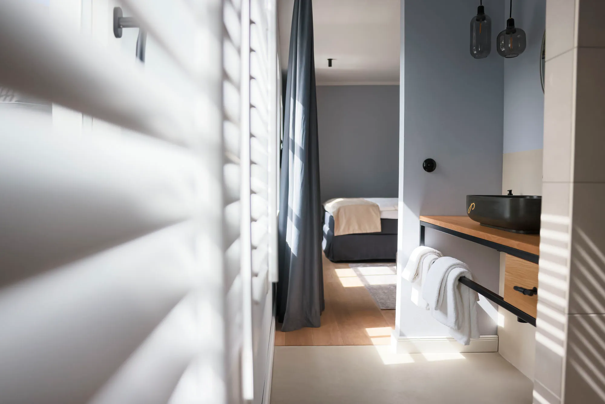 Blick vom Bad durch das Zimmer zum Bett
